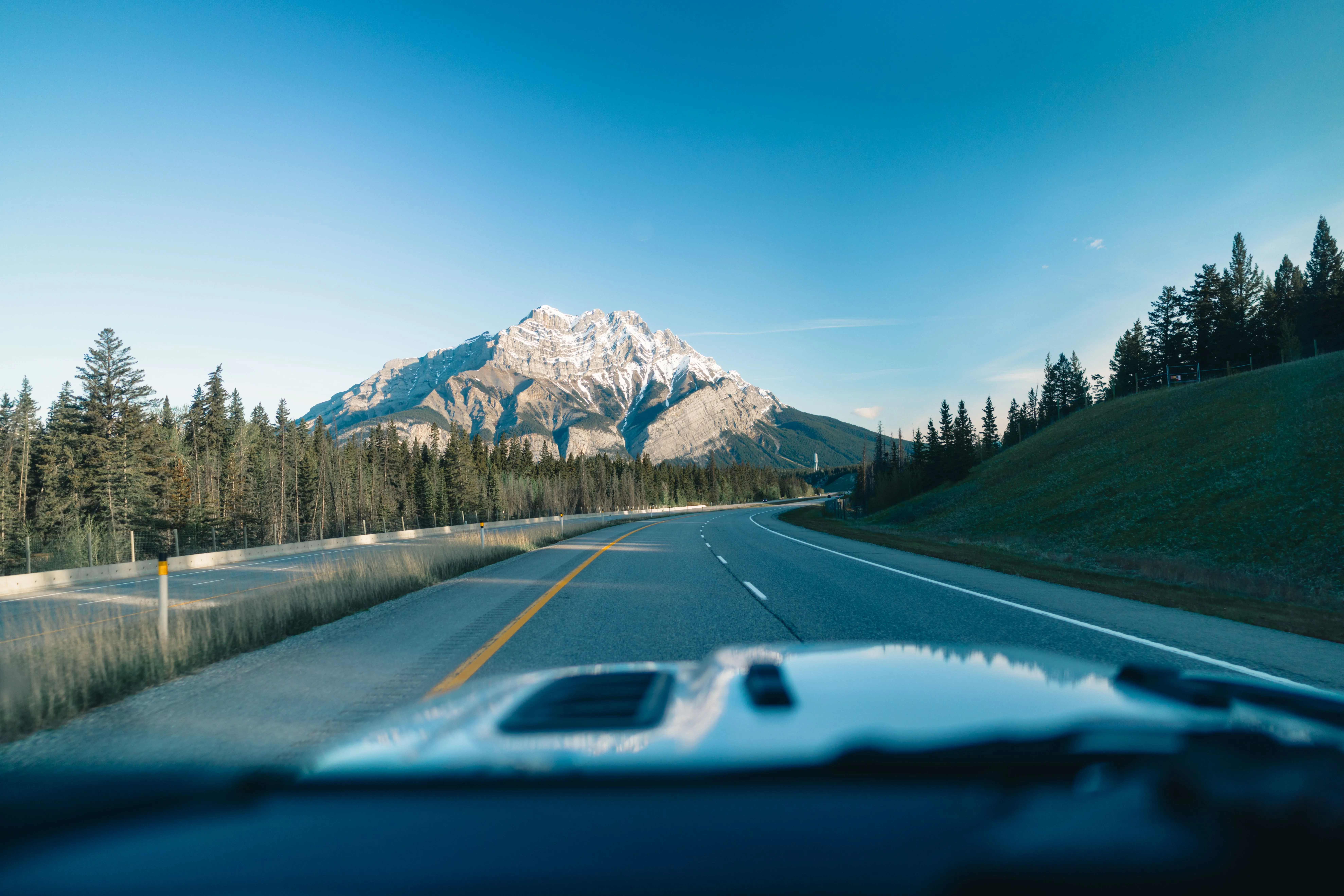 Cars driving surrounded by Rocky Mountain scenery in Banff National Park, Alberta.